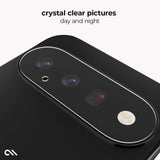 A close-up of a black smartphone showing the rear camera area with a clear, rounded camera surround and the text 'crystal clear pictures day and night' above it.