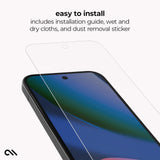 A clear tempered glass screen protector is shown floating above a smartphone, with text reading 'easy to install' and 'includes installation guide, wet and dry cloths, and dust removal sticker.' The phone screen displays a blue and green wallpaper, and the background is a very light gray studio-style backdrop.