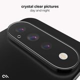 A close-up of a black smartphone camera module with three lenses and a flash, shown on a light gray background with the text 'crystal clear pictures day and night' and a small white logo in the lower left.