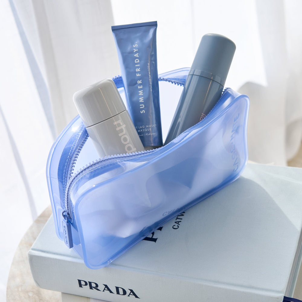 Blue cosmetic bag with skincare products on a  book Jelly Makeup Bag #color_carolina blue