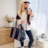 Girl taking mirror selfie with tote on her arm 
#color_navy rugby stripe
