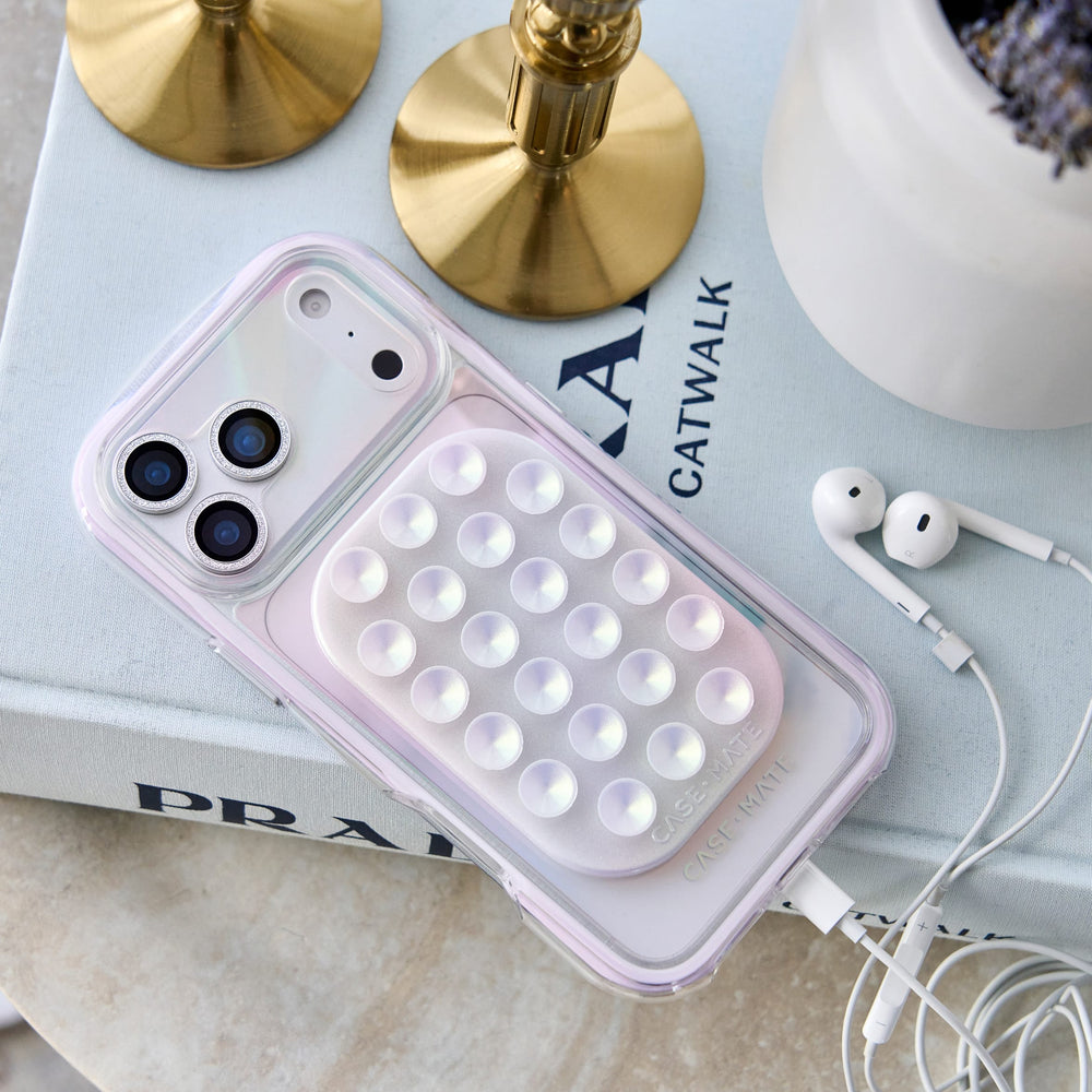 A clear phone case with a built-in LED light panel, shown resting on a light blue book with gold candlesticks and white earbuds nearby.
 #color_jelly pop iridescent