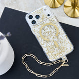 A clear phone case with gold foil flakes and a large gold circular MagSafe ring, shown on a phone with a matching gold chain strap, styled on a dark surface with gold candle bases in the background.

#color_karat
