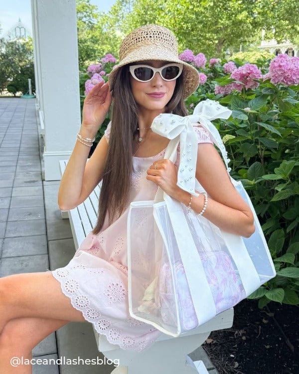 Girl sitting outside on bench with straw hat and Ivory Pearl Bow Jelly Tote Bag