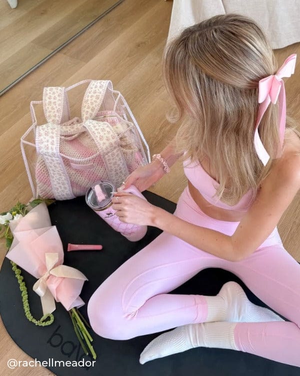 Girl in pink workout set on black pilates mat with Quilted Ditsy Floral Jelly Tote