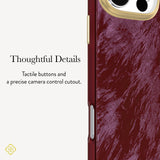 Close-up of a phone case with a textured deep burgundy-red back panel, gold-tone side buttons, and a gold camera ring, shown next to marketing text that reads 'Thoughtful Details' and 'Tactile buttons and a precise camera control cutout.'.