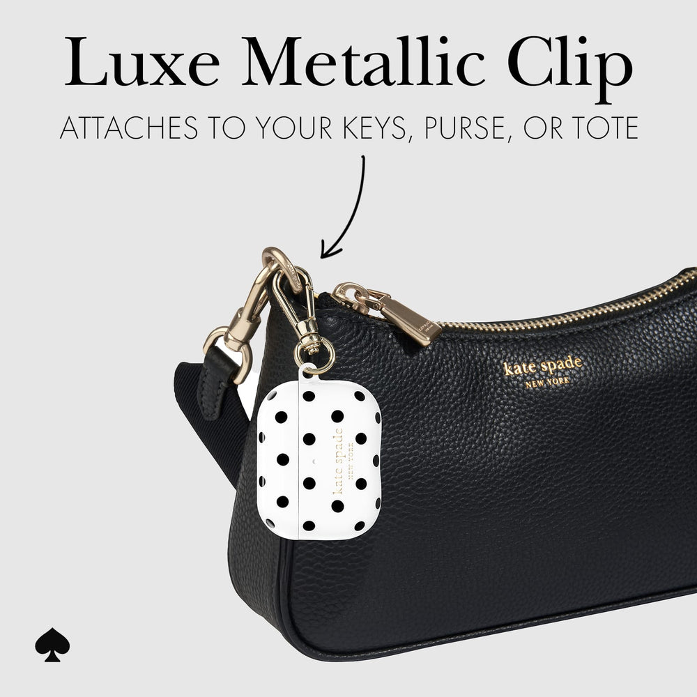 Kate Spade black textured leather pouch with gold-tone hardware and a white keychain charm covered in black polka dots. Text at the top reads 'Luxe Metallic Clip' and 'ATTACHES TO YOUR KEYS, PURSE, OR TOTE'.