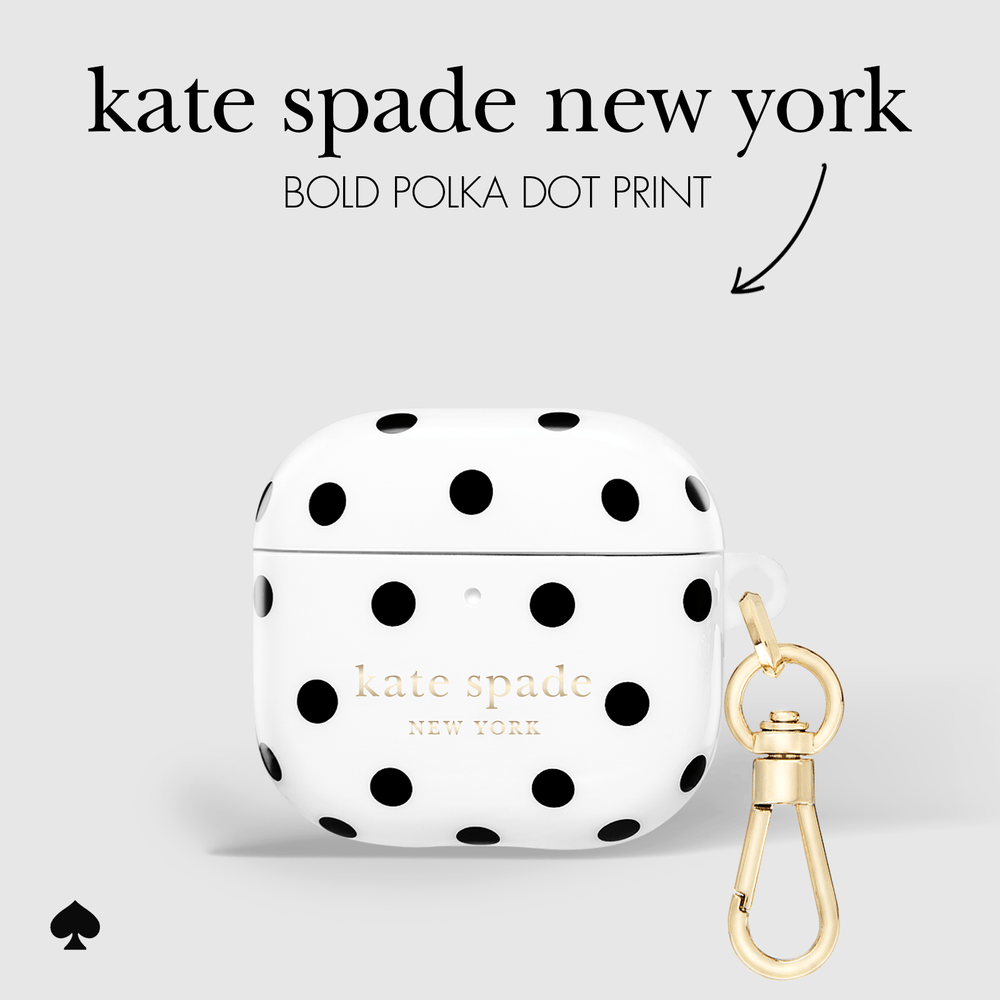 White AirPods case with bold black polka dots and gold Kate Spade New York lettering, shown with a gold carabiner clip on a light gray background with text reading 'kate spade new york' and 'BOLD POLKA DOT PRINT'.