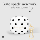 White AirPods case with bold black polka dots and gold Kate Spade New York lettering, shown with a gold carabiner clip on a light gray background with text reading 'kate spade new york' and 'BOLD POLKA DOT PRINT'.