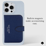 Kate Spade New York phone case with a navy blue textured wallet-style magnetic card holder attached to a light blue and white striped phone case. The image includes the text 'Built-in magnets make accessorizing easy.
