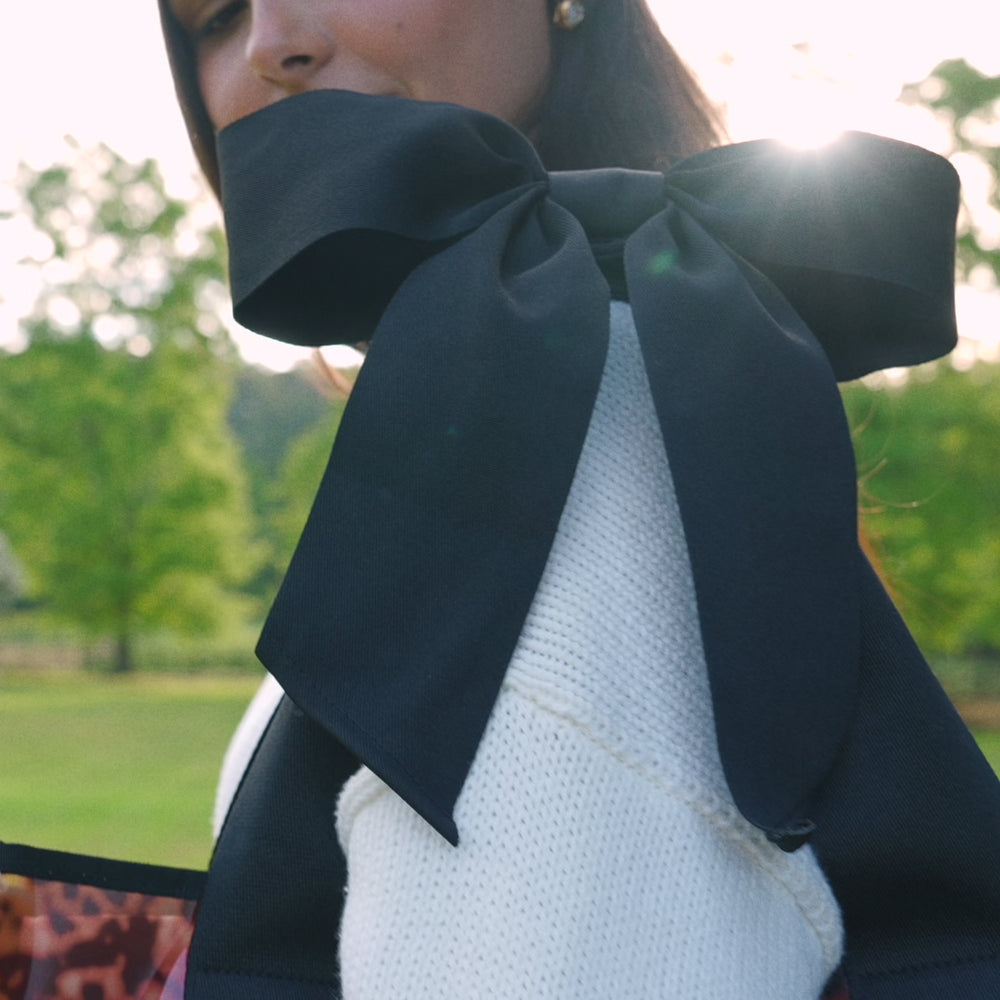 Woman walking by the water with a tote bag on her shoulder #color_tortoiseshell bow