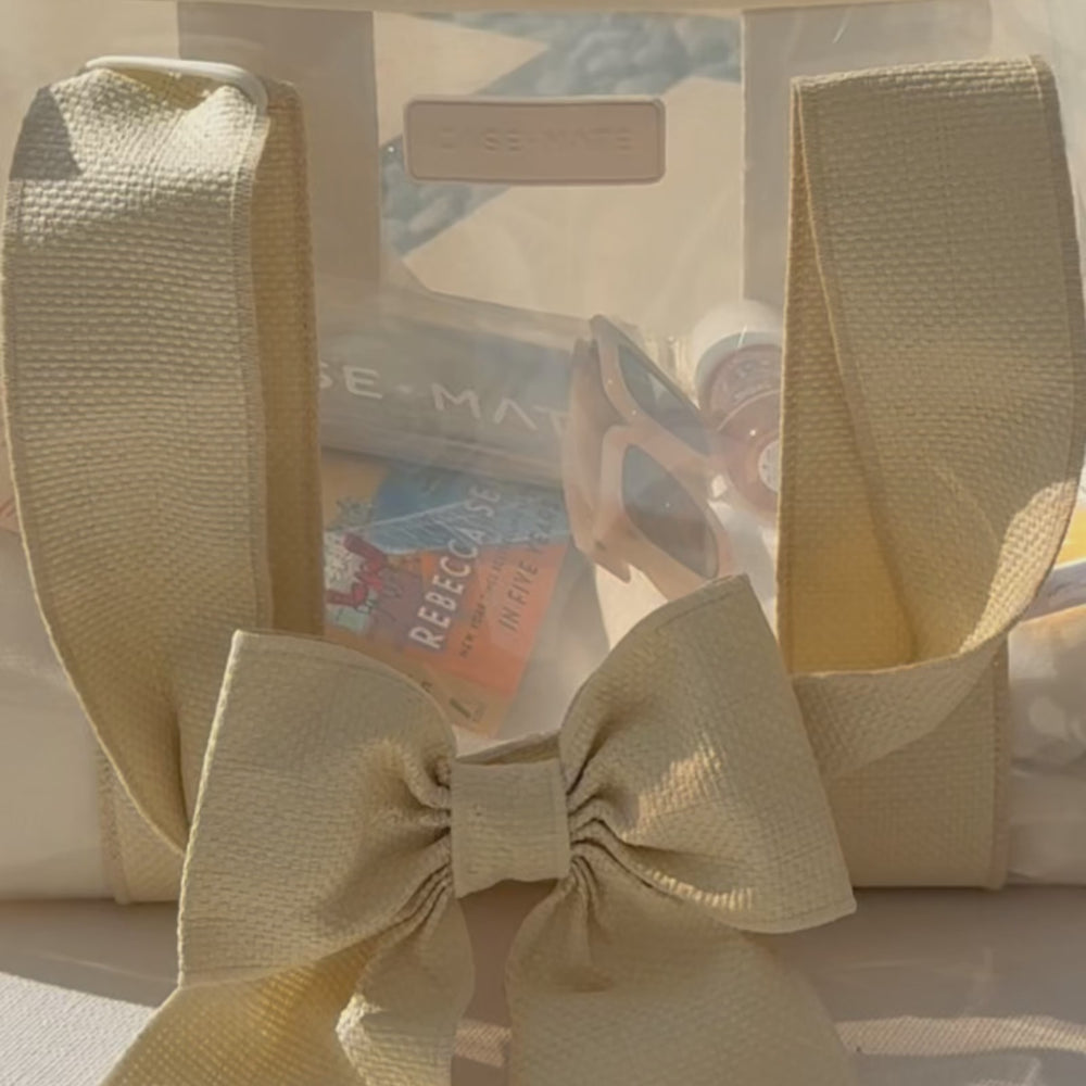A woman packing ecru raffia bow jelly tote to show what all can fit inside
#color_raffia bow