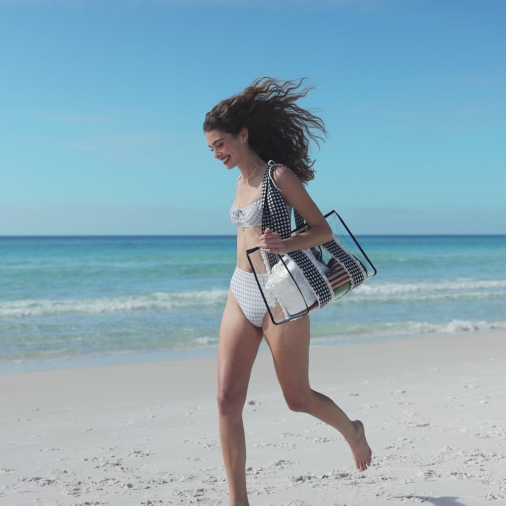 woman walking on beach with gingham tote bag #color_navy gingham