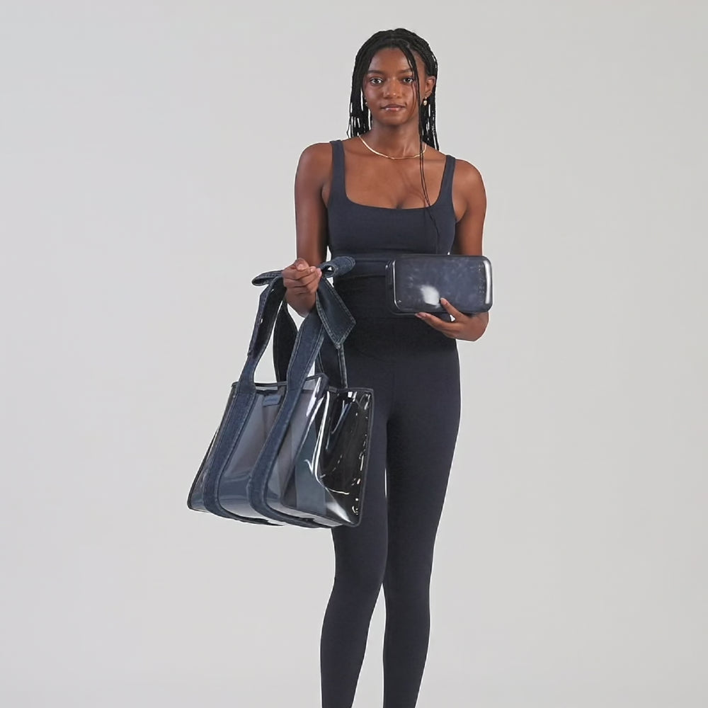 Woman walking in, putting the tote bag on her shoulder, and walking out of frame.

#color_dark wash denim bow