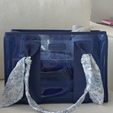 A woman showing off her medium jelly tote
#color_something navy twilly 