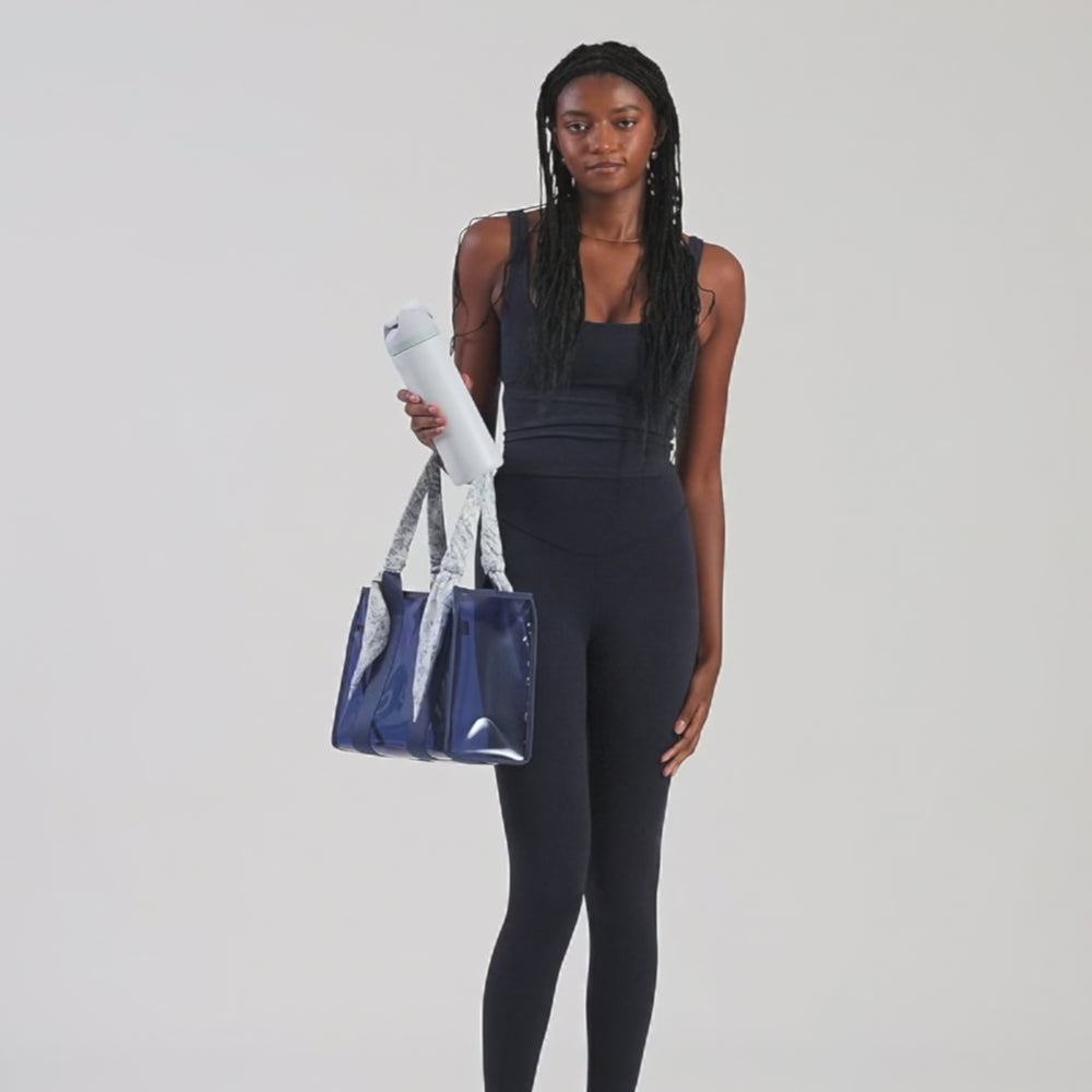 A woman showing off her medium jelly tote
#color_something navy twilly 