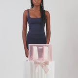 A woman showing off her medium jelly tote
#color_ballet pink bow