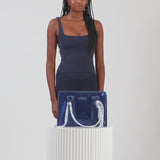 A woman showing off her medium jelly tote
#color_something navy twilly 