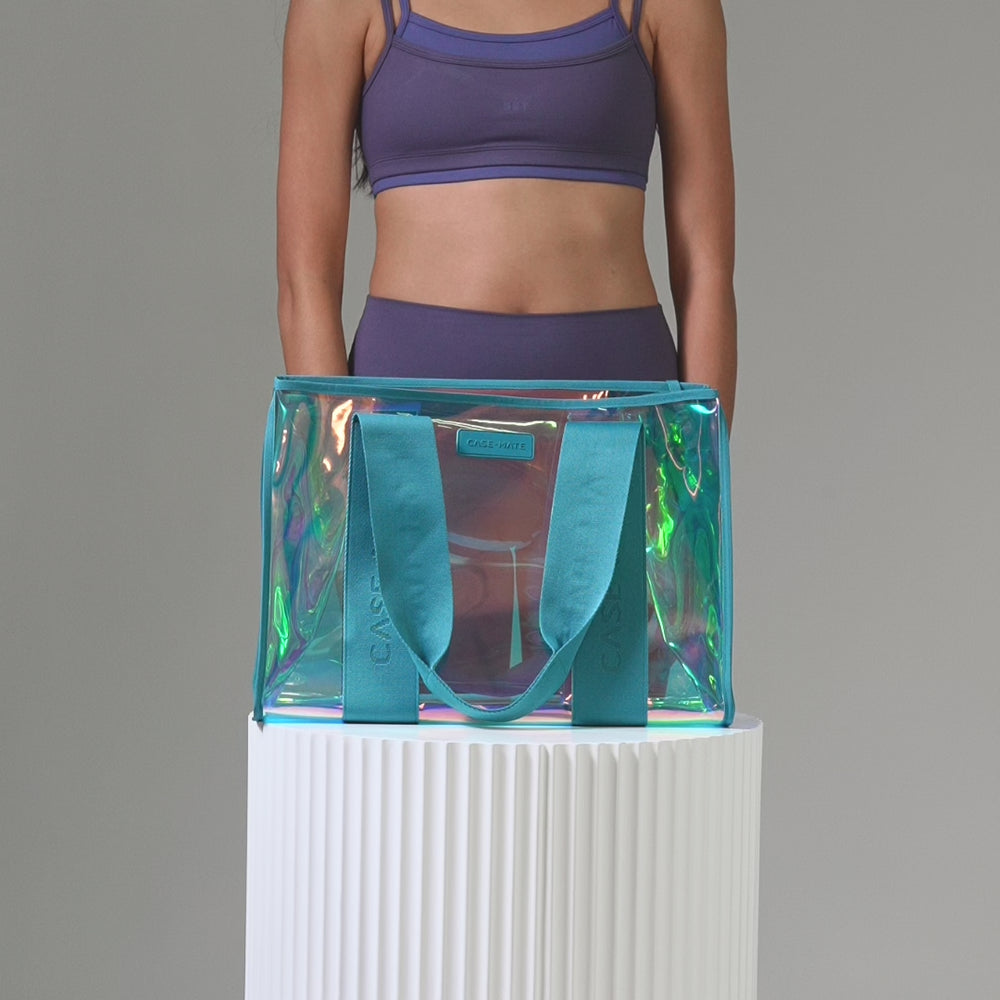 A woman packing a Emarld Soap bubble tote bag showing how much stuff can fit into a bag
#color_emerald blue iridescent