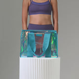 A woman packing a Emarld Soap bubble tote bag showing how much stuff can fit into a bag
#color_emerald blue iridescent