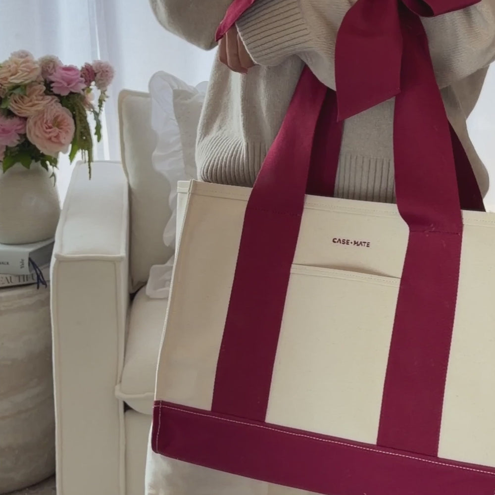 Woman packing up her canvas tote with various items.

#color_cranberry bow