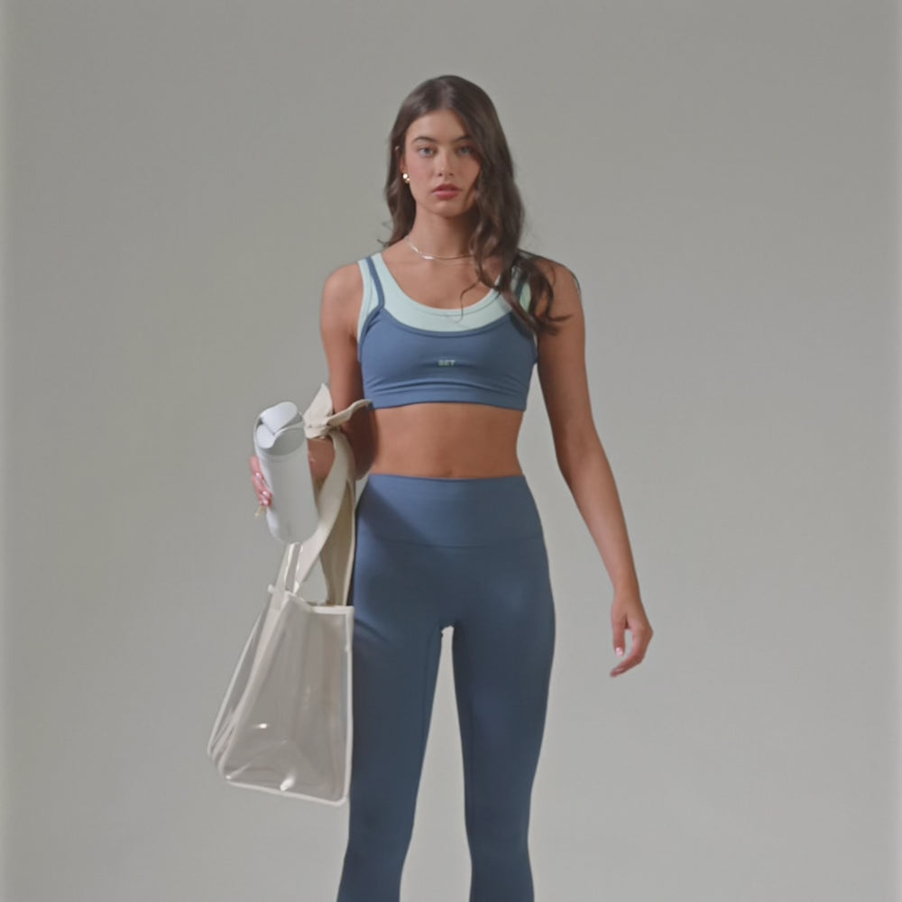 A woman showing off her ercu raffia bow jelly tote bag 
#color_raffia bow