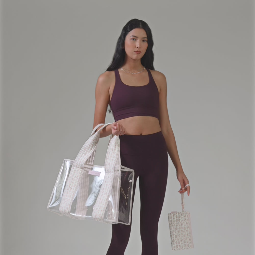 A woman in a plum workout outfit showing her quilted ditsy floral tote bag
#color_quilted ditsy floral 