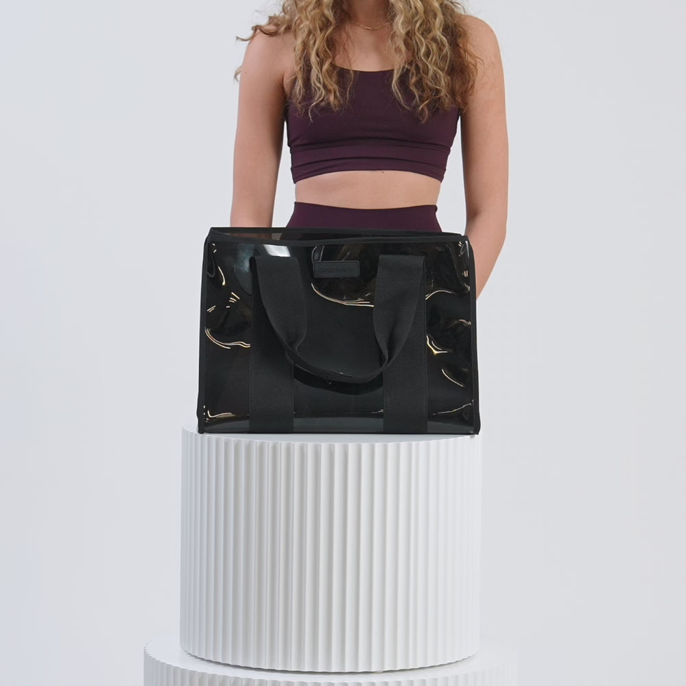 A woman packing the Midnight Black Jelly Tote with her accessories
#color_midnight black