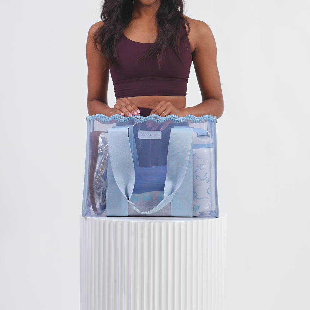 A woman packing her Carolina Crotchet Wave Jelly Tote full of her accessories
#color_carolina blue crochet wave
