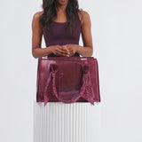 Woman in athleisure wear packing Mullberry Twilly Tote
#color_mulberry twilly