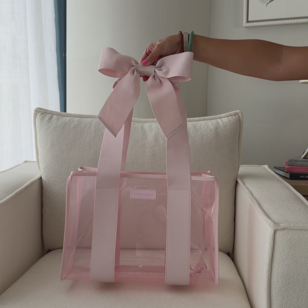 A woman showing off medium tote 
#color_ballet pink bow