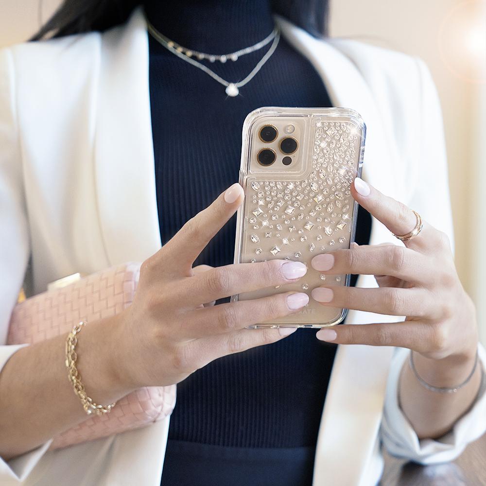 Woman holding fashion iPhone case. color::Karat Crystal