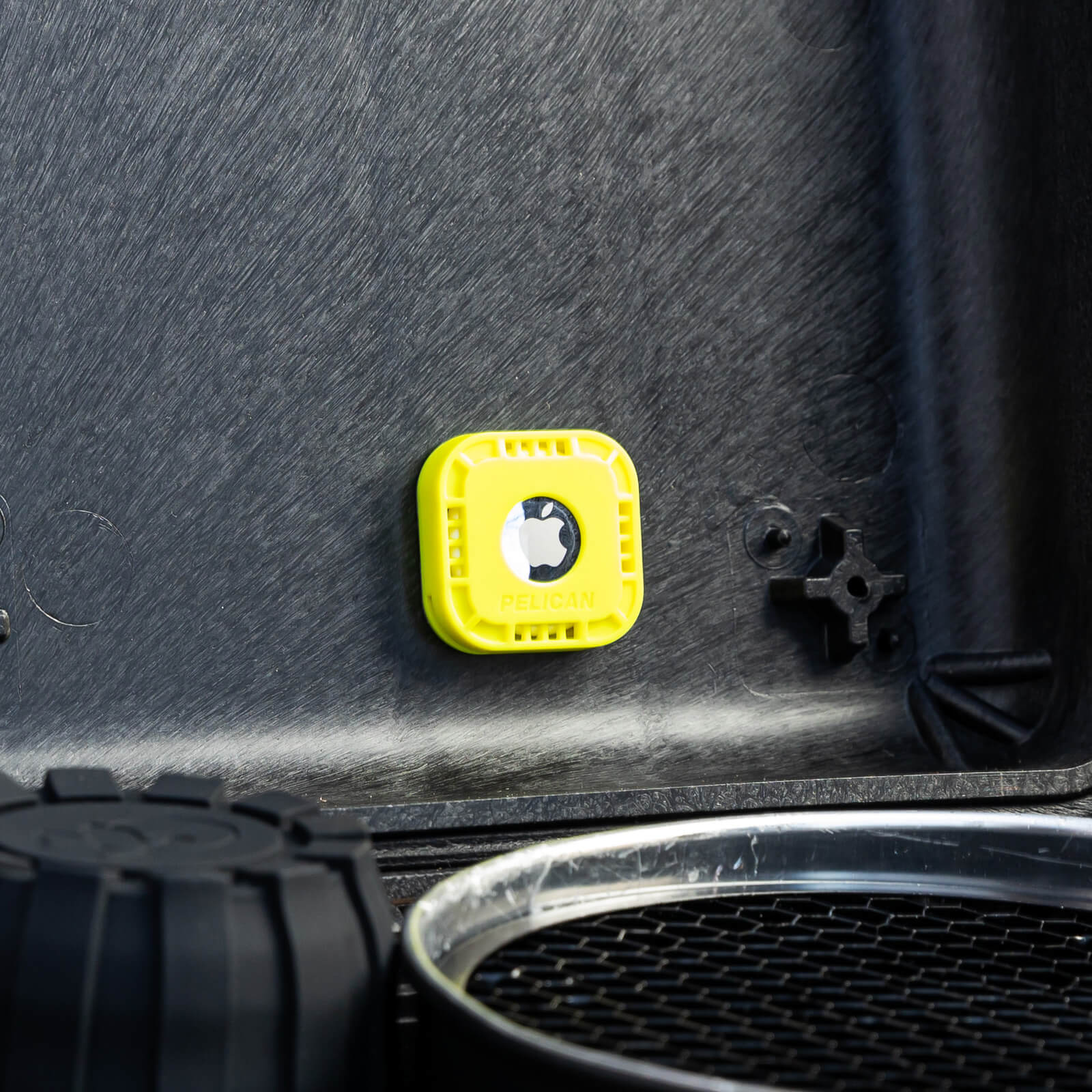 AirTag case stuck to inside of a gear carrier. color::Hi-Vis Yellow