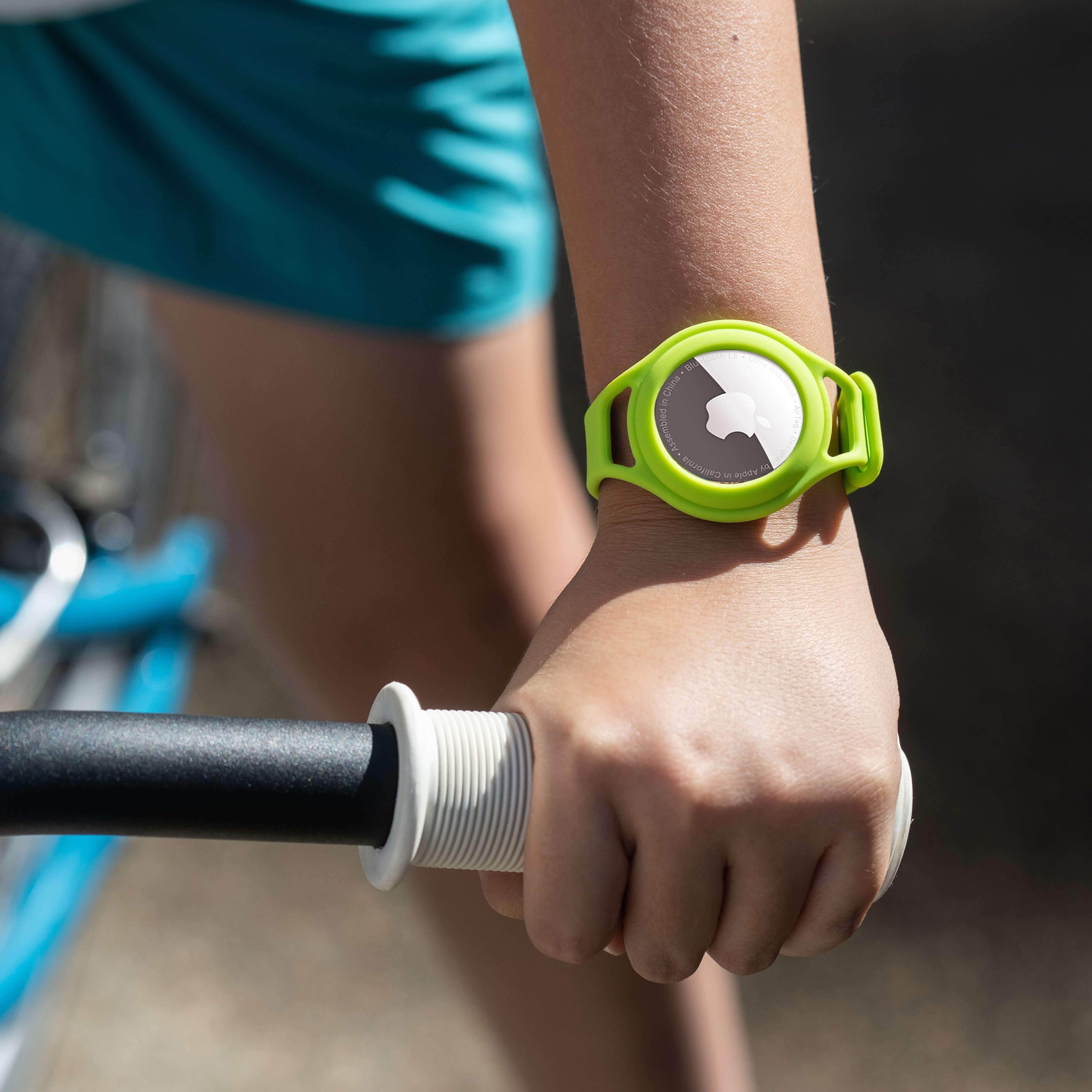 Kid riding a bike while wearing Lime Green AirTag bracelet on wrist. color::Lime Green