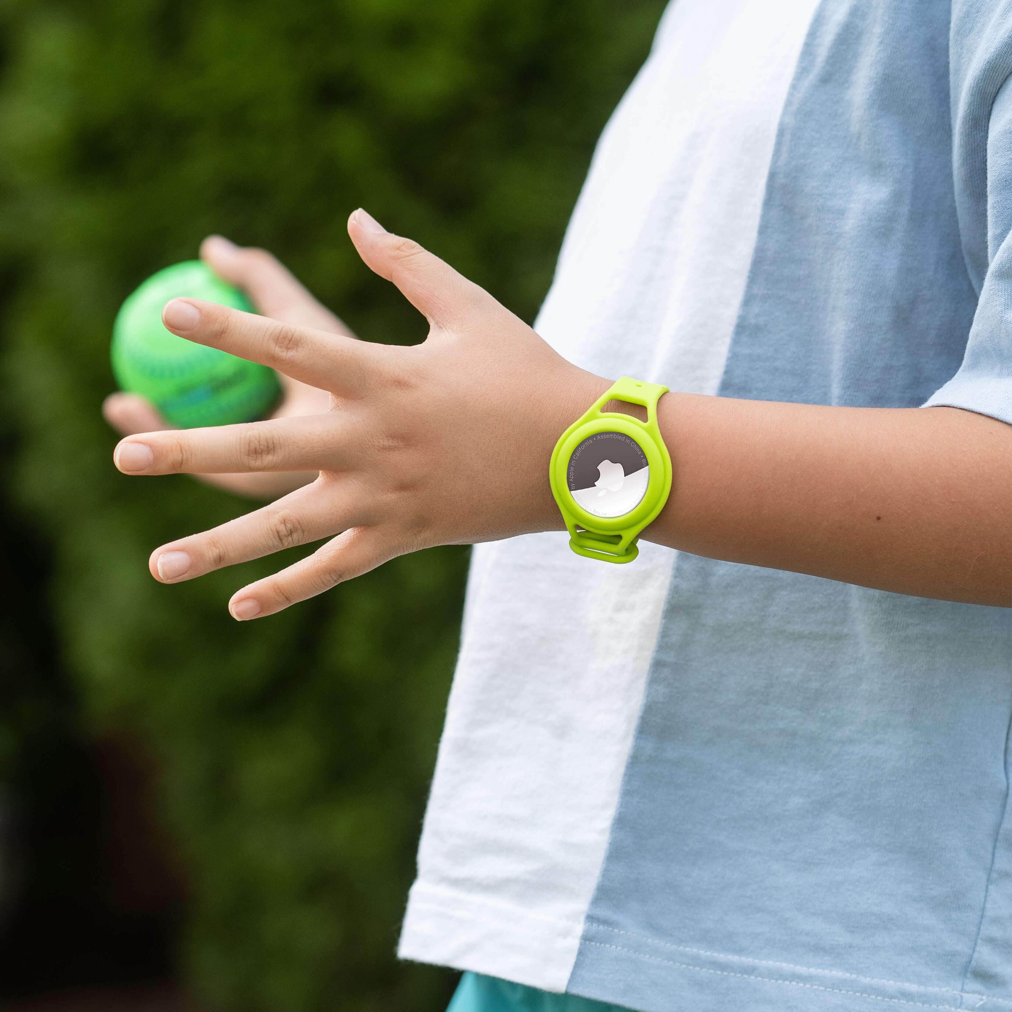 Kid playing ball while wearing tracker strap for AirTag. color::Lime Green