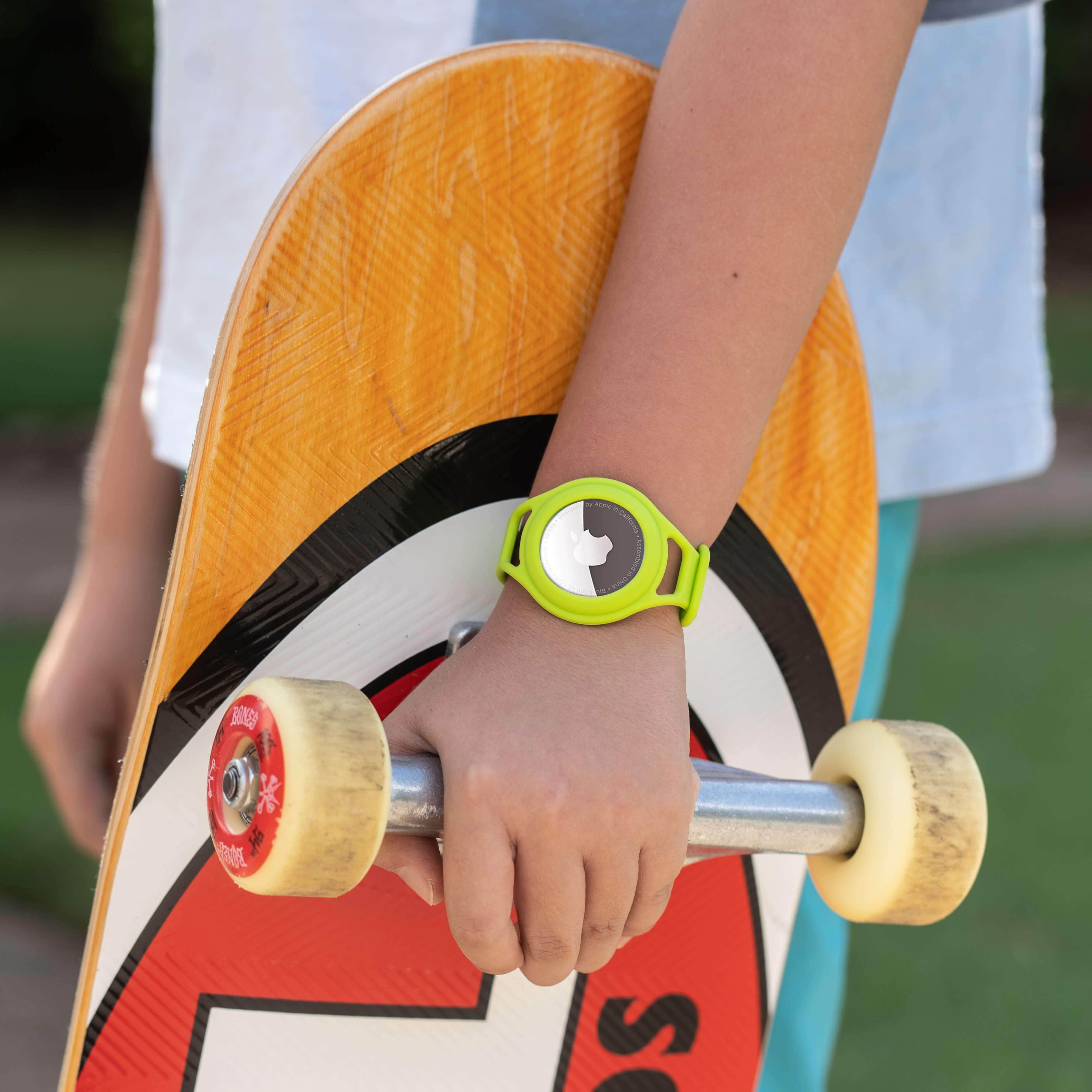 Child wearing AirTag bracelet while holding skateboard. color::Lime Green