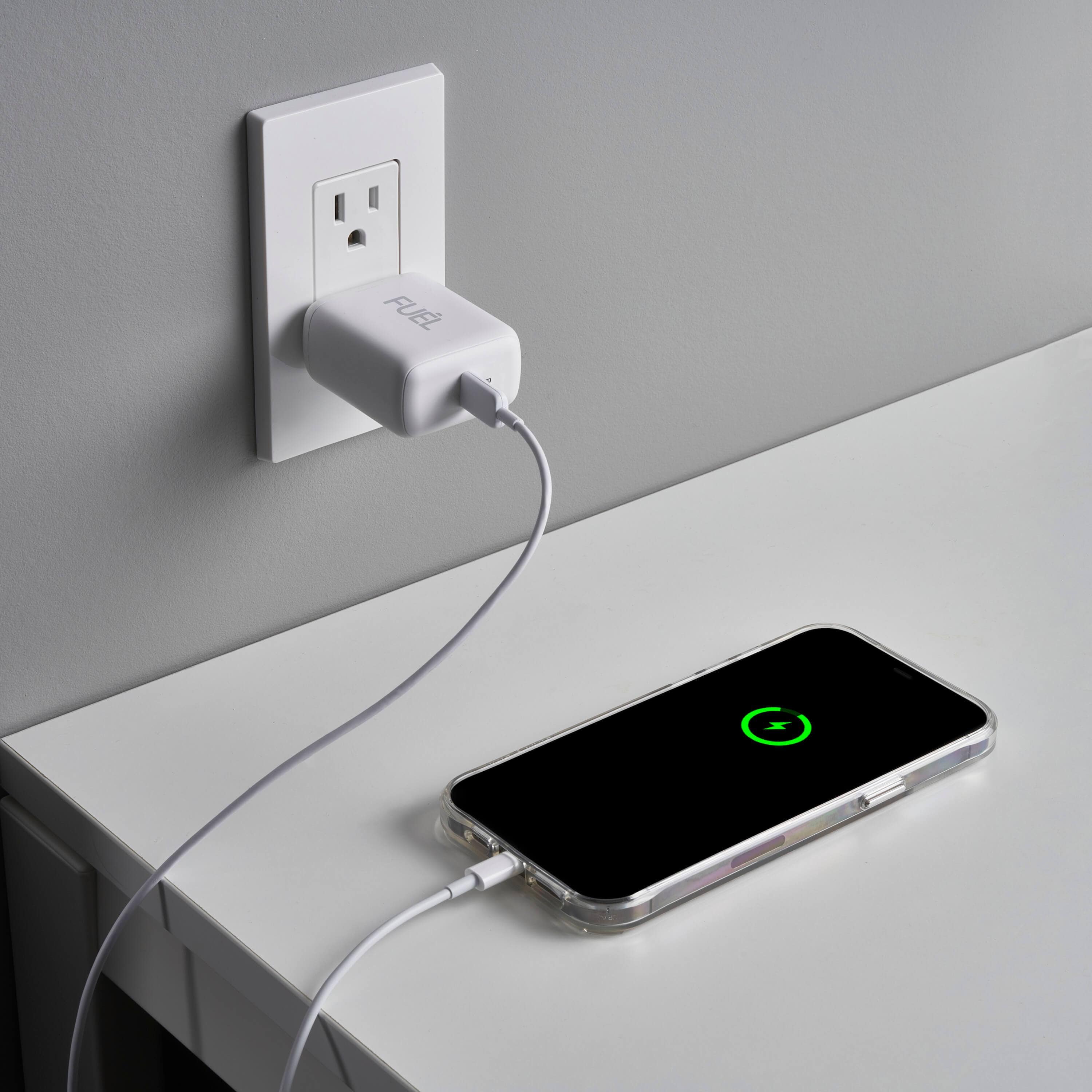 FUEL 30W Power Adapter plugged into wall charging phone. color::White