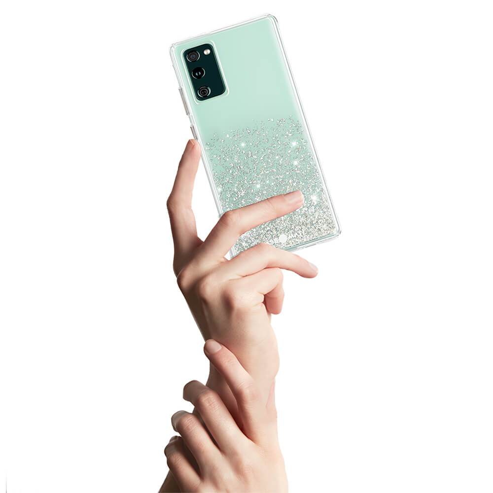 and holding Galaxy S20 FE 5G with twinkle ombre. color::Twinkle Stardust