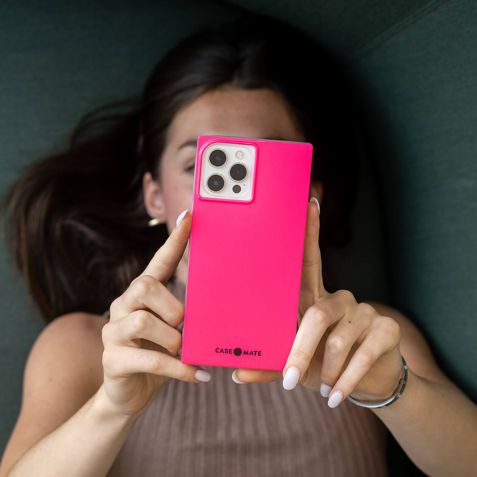 Woman holding Hot Pink square case out in front of her. color::Hot Pink