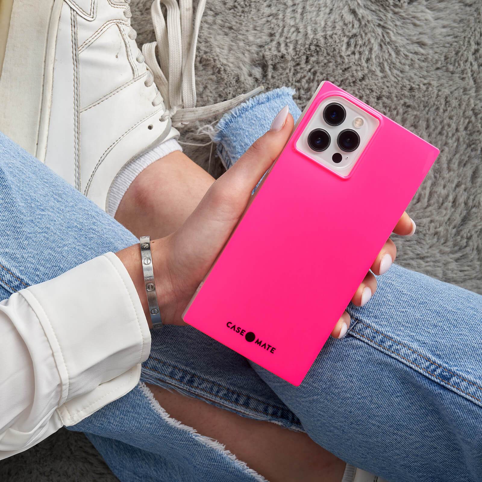 Hot Pink BLOX square case sitting in lap. color::Hot Pink