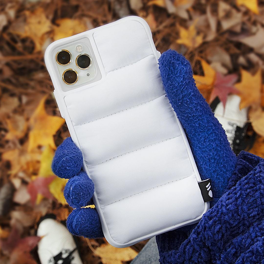 Hand holding puffer jacket inspired iPhone 11 Pro case. color::White Puffer