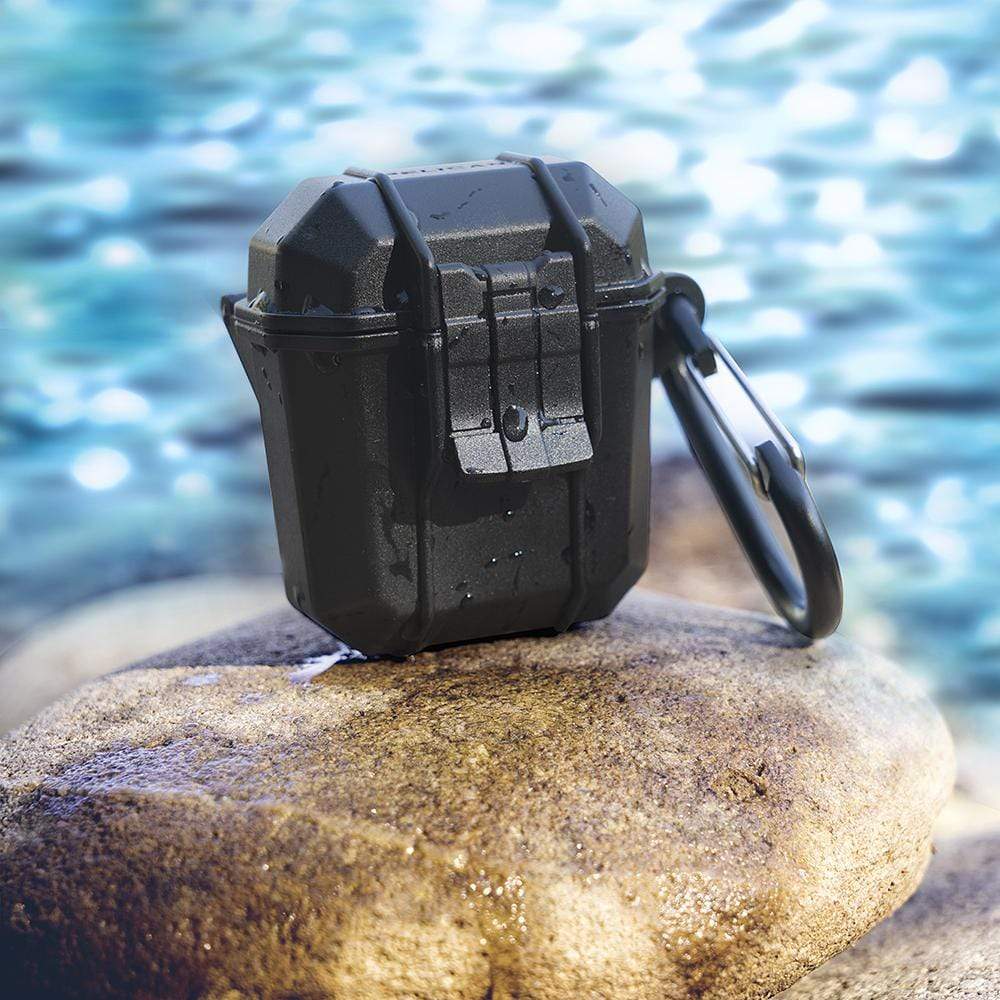 Black Pelican Marine AirPods case sitting on a rock. color::Black