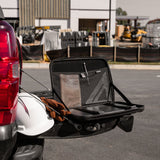 Black laptop sleeve with mesh pockets and shoulder strap, displayed open on vehicle hitch.