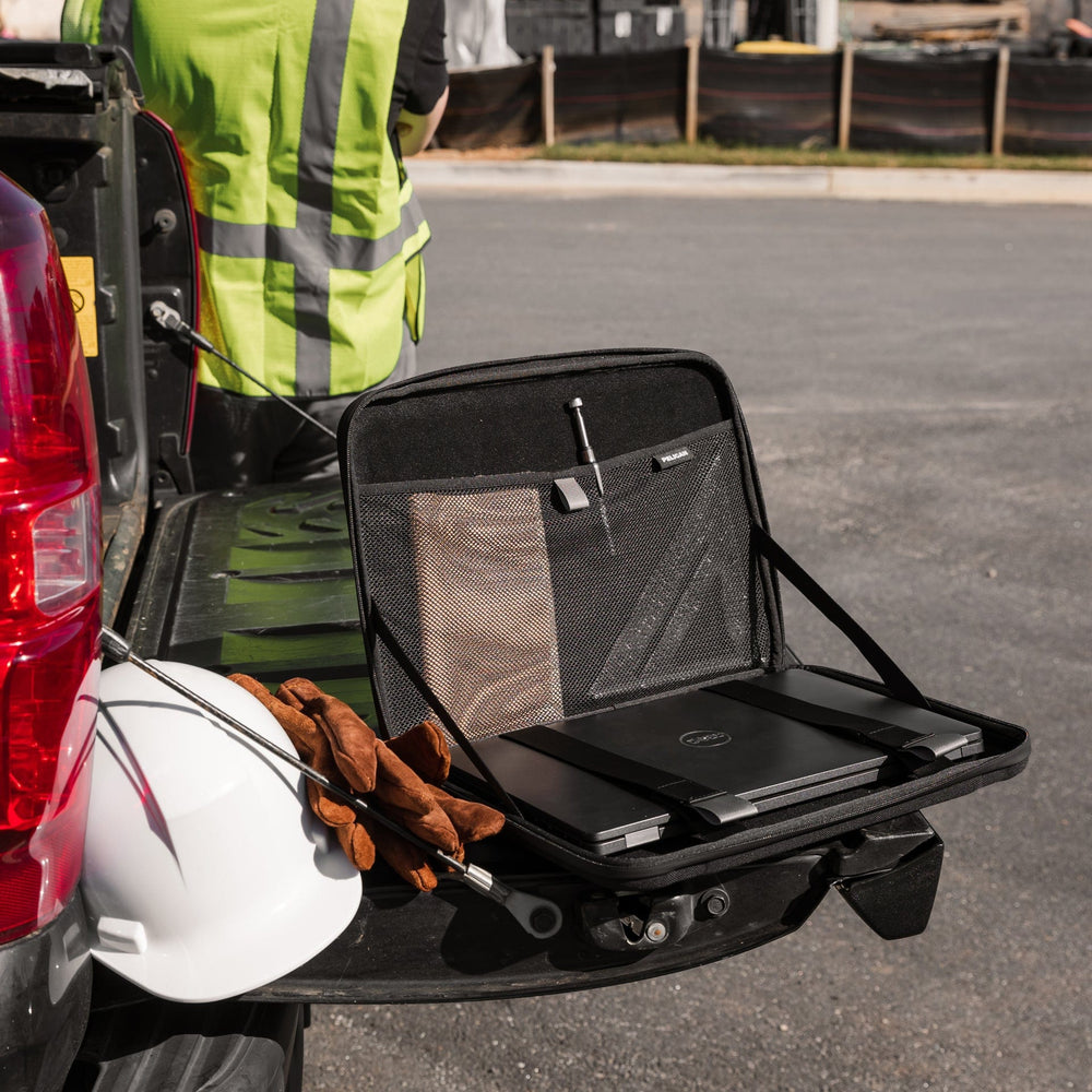 Black laptop sleeve with mesh storage compartments, open on vehicle hitch, containing laptop and accessories.