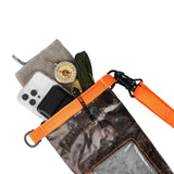 Hunter camo dry bag with orange shoulder strap holding phone, compass, and other small items.