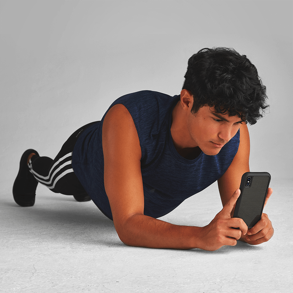 Man planking while holding Protective iPhone Xs/ X case. color::Carbon Fiber
