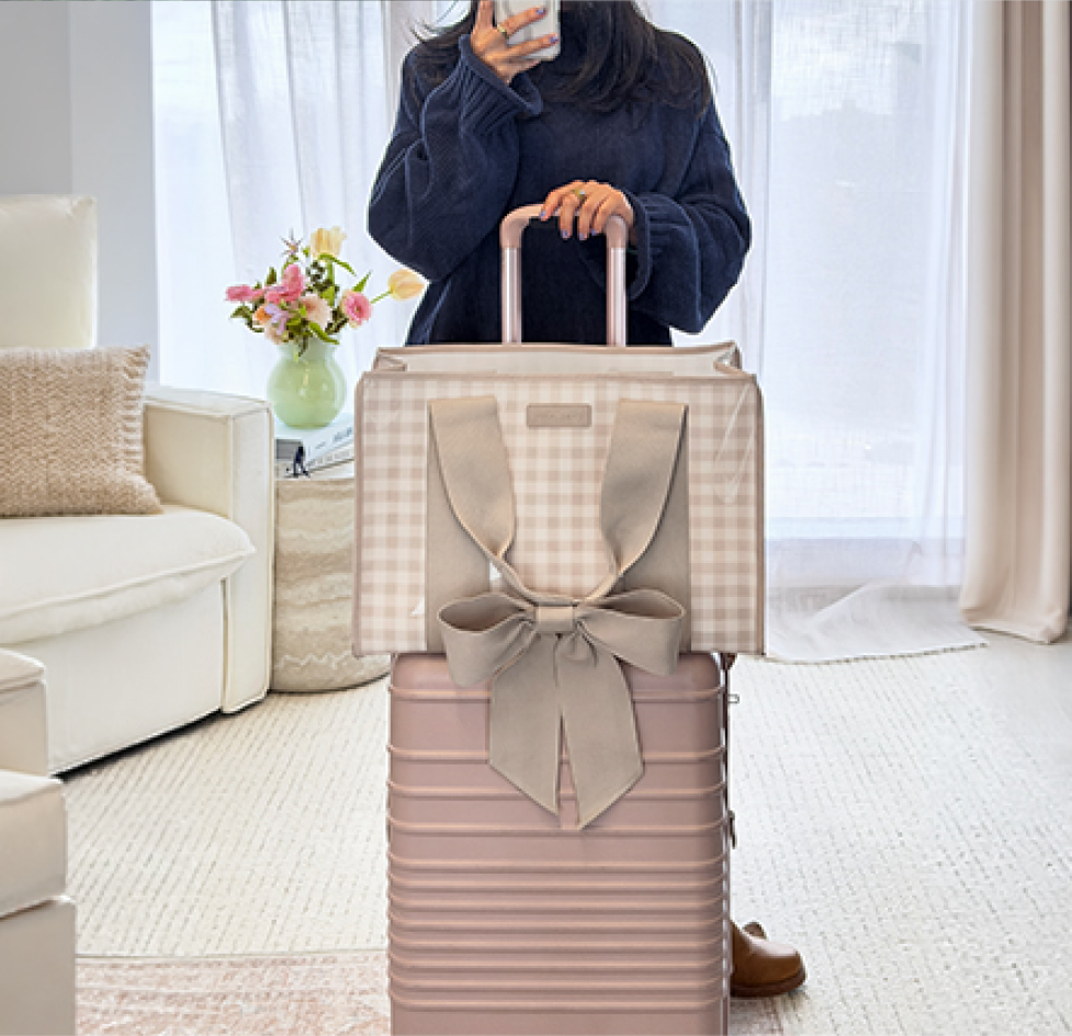 The jelly tote resting on a carry-on suitcase